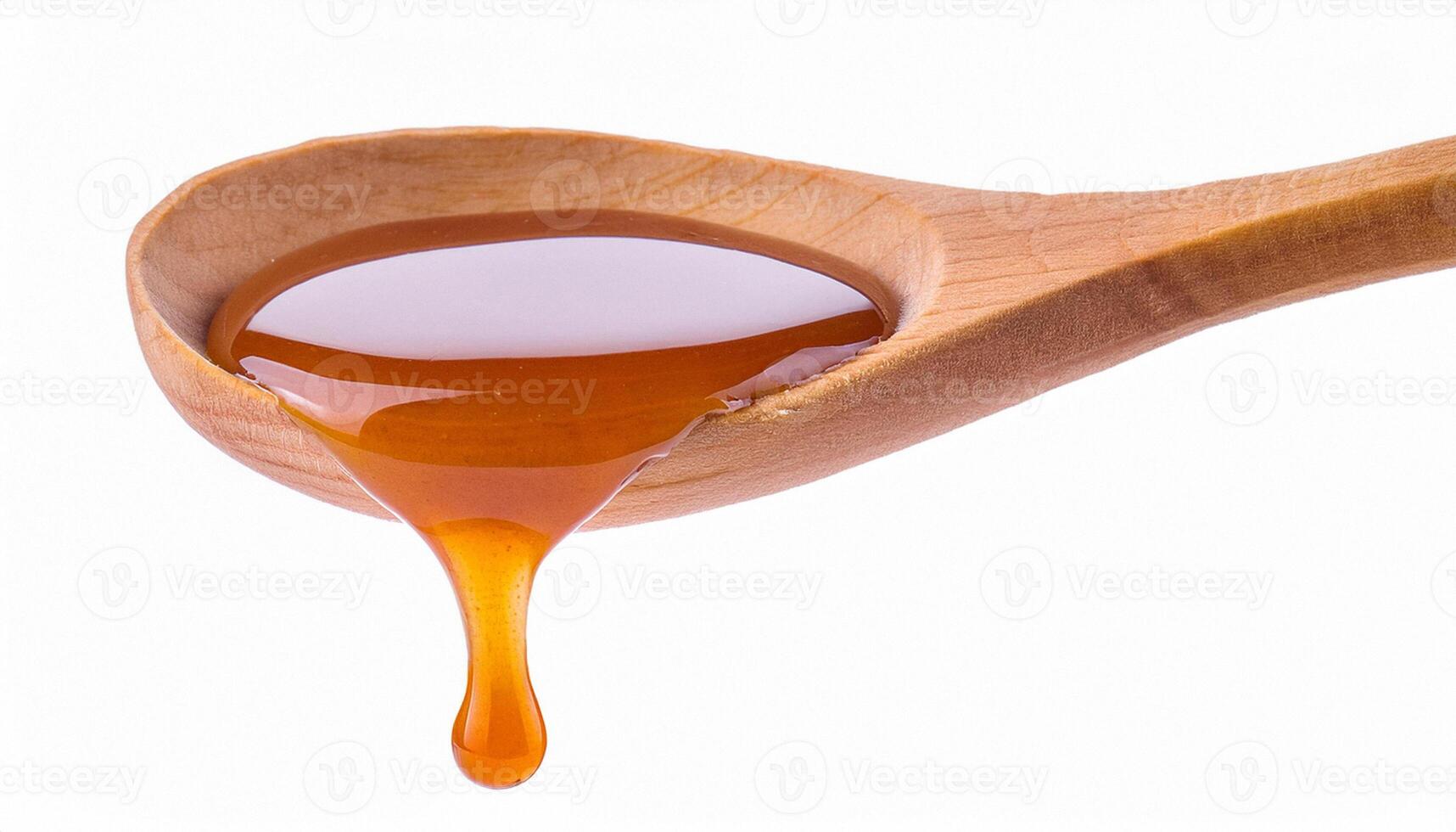 Drip of caramel in a syrup from wooden spoon isolated on white background photo