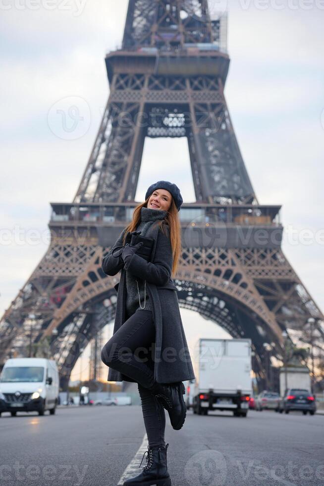 Parisian Style Woman in Grey Coat and Beret on Highway with Eiffel Tower photo