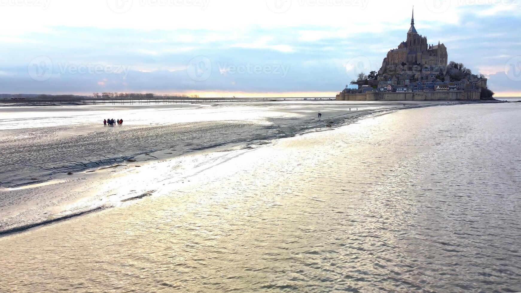 Aerial View of Group Walking on Tidal Flats to Mont Saint Michel Normandy photo