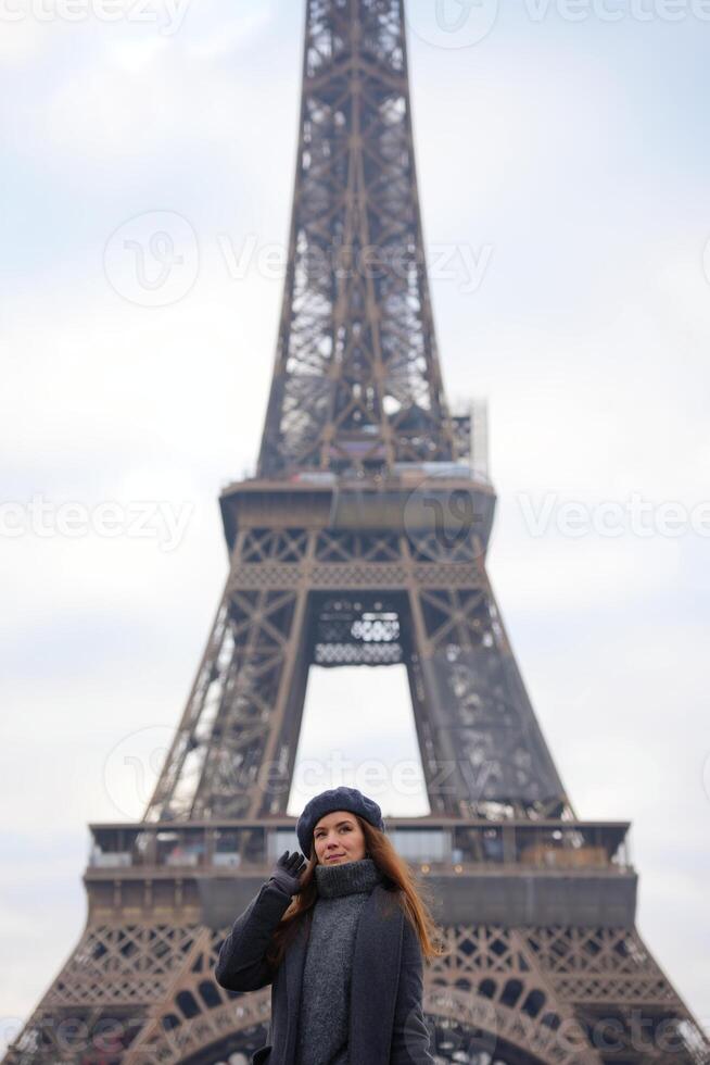 Parisian Woman in Beret and Grey Coat Poses on Highway with Eiffel Tower photo