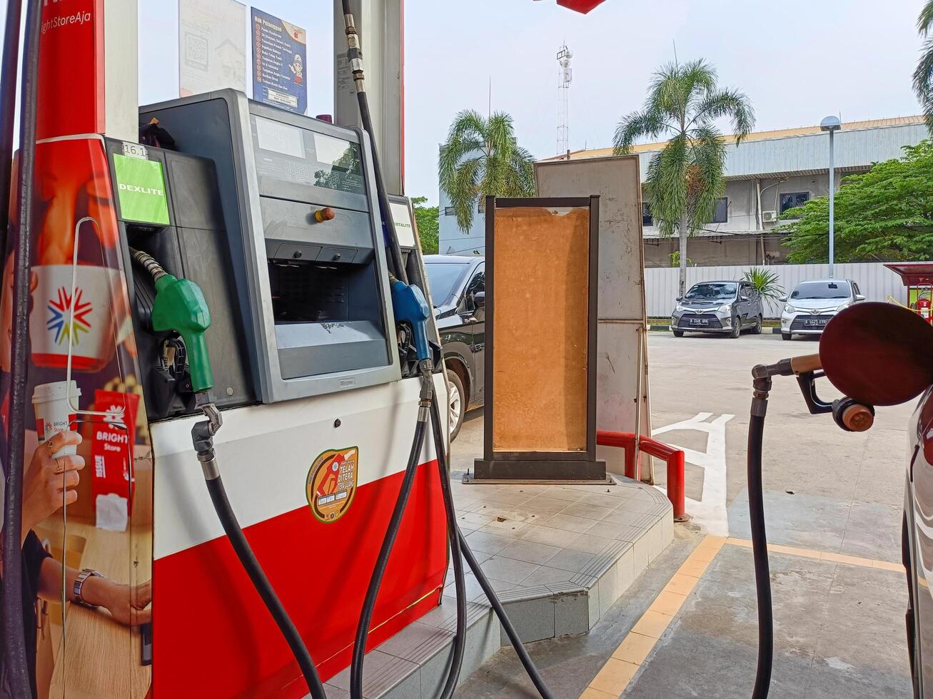 Jakarta, Indonesia, 2024 - A car refueling at a gas station in Jakarta. A Pertamina fuel filling machine with various types of fuel. photo