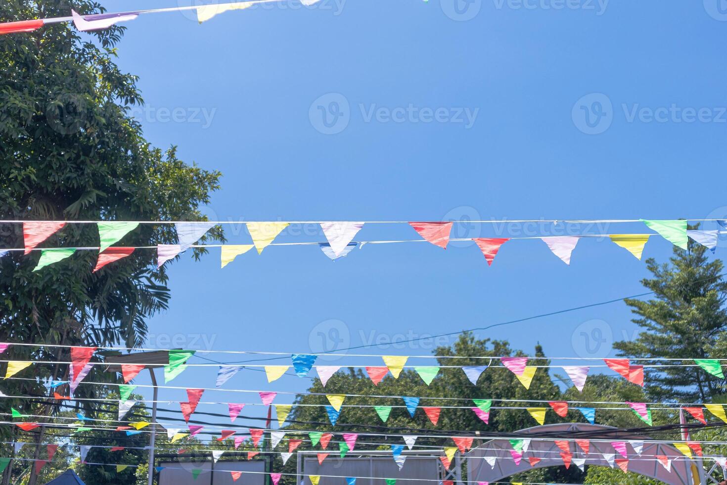 The colorful flags between the trees at a celebration event photo