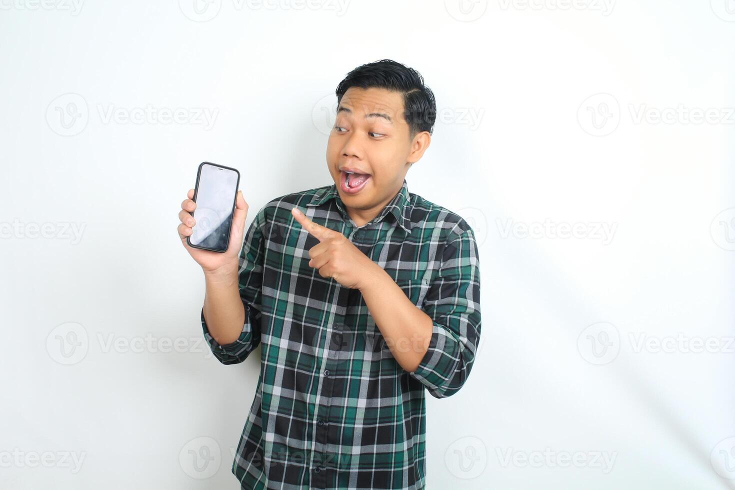surprised asian man pointing smartphone screen with amazed expression isolated on white background photo
