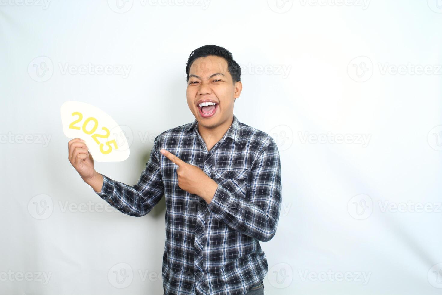 excited asian man screaming and pointing to 2025 new years eve greeting card hold on his hand isolated on white background photo