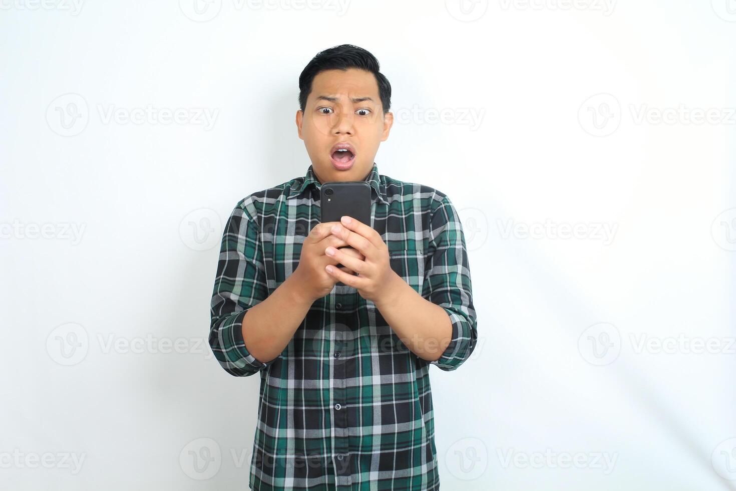 shocked asian man looking at smartphone show confused expression isolated on white background photo