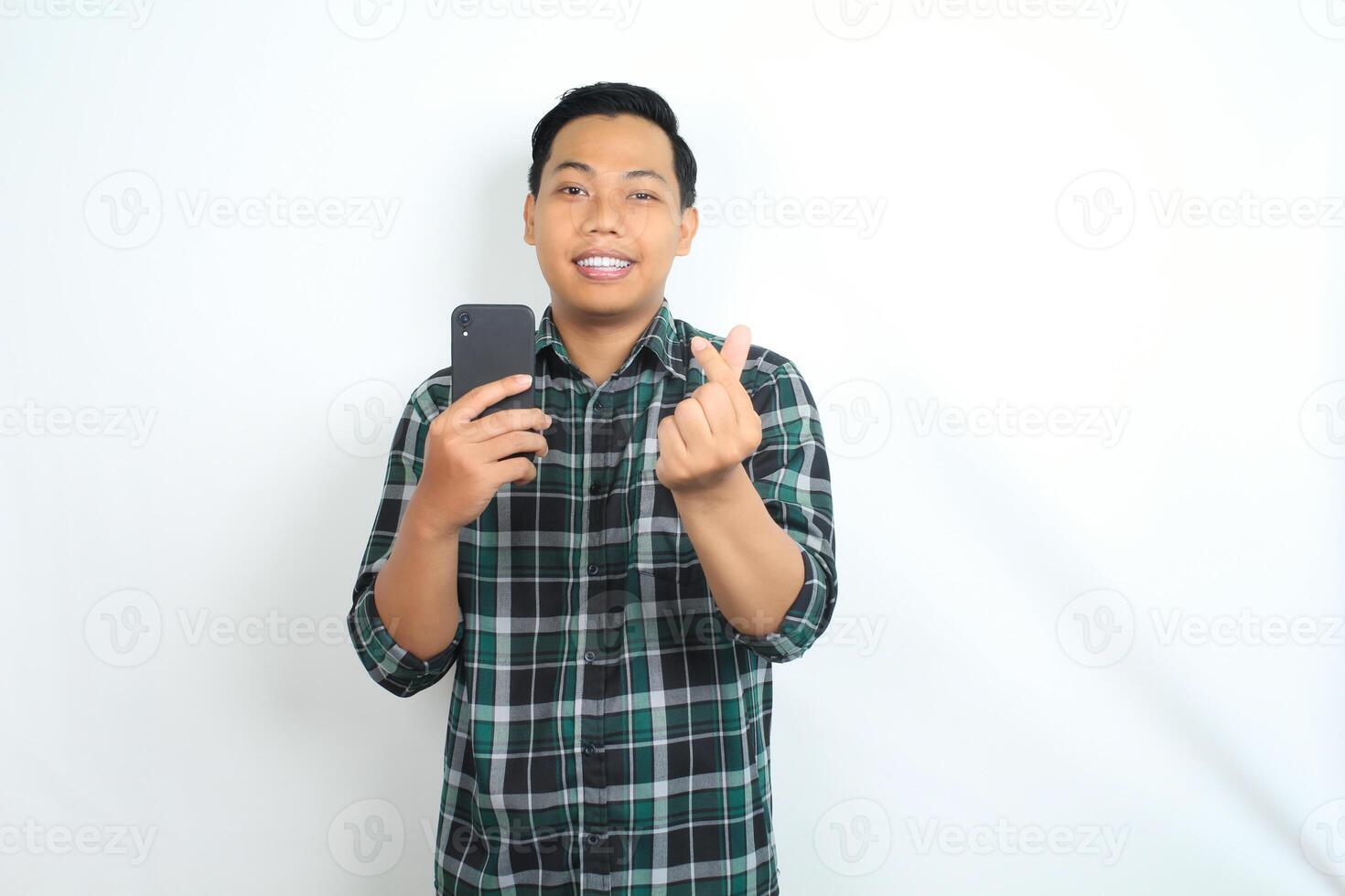 happy asian man holding cellphone wear casual shirt show love signs with smiling face isolated on white background photo