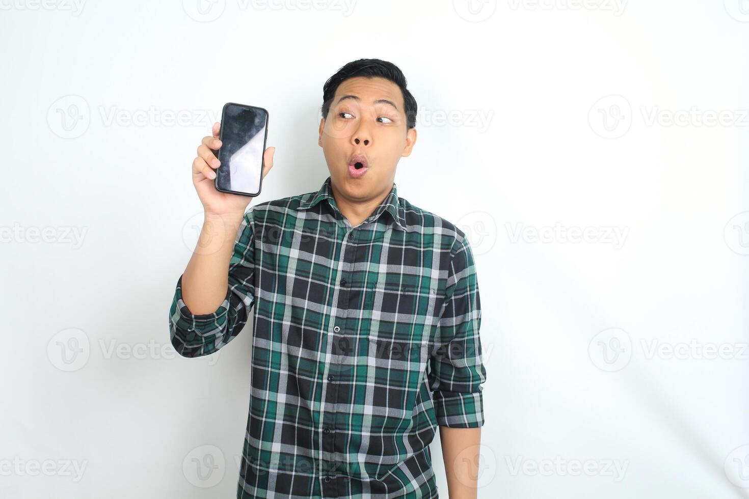attractive asian man show smartphone screen with surprised face expression isolated on white background photo