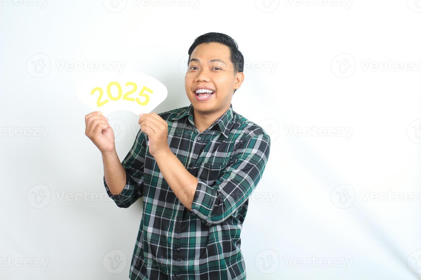 isolated happy asian man celebrating new year eve with holding 2025 card wearing casual clothes photo