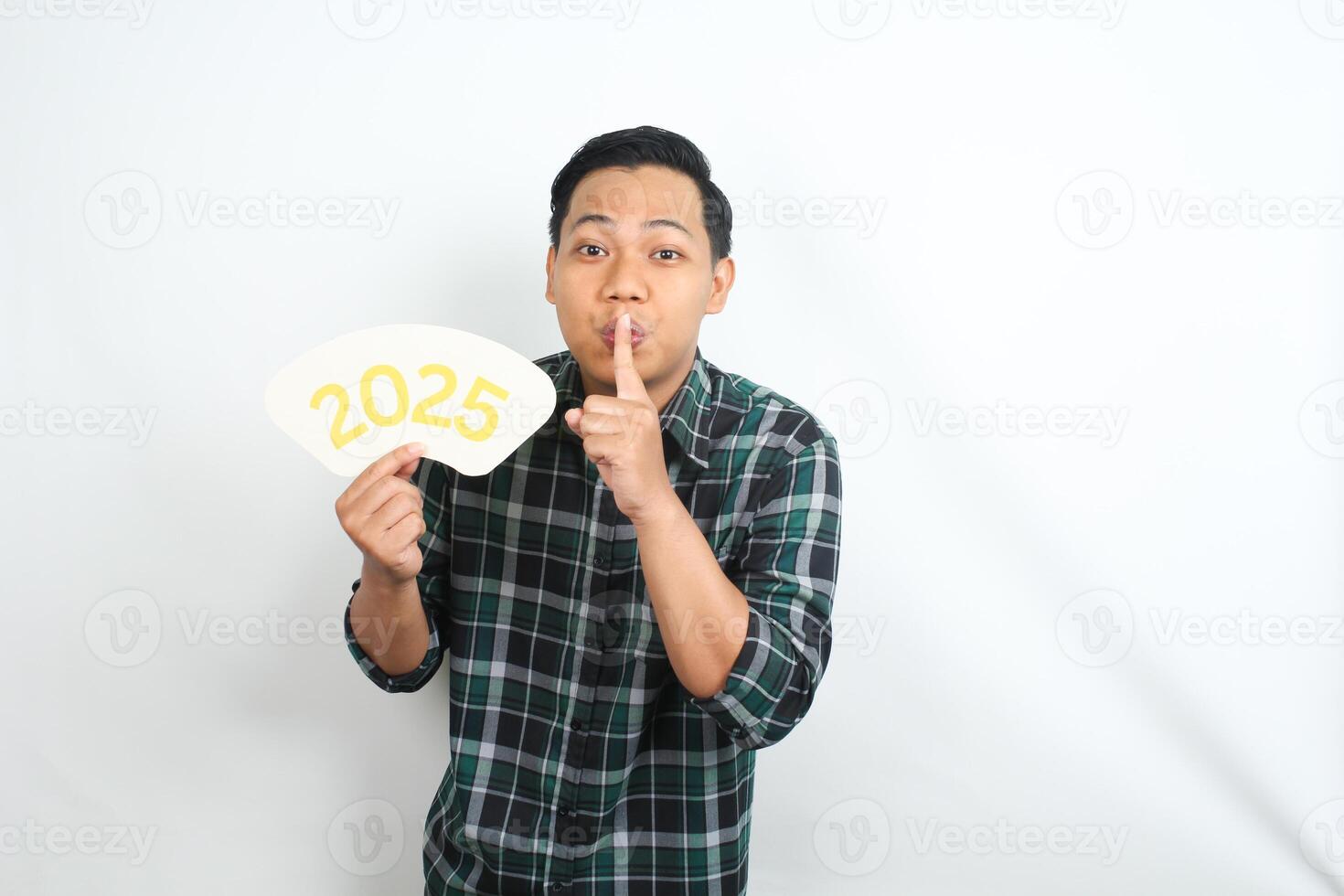 playful asian man showing silent gesture and 2025 new years eve sign board isolated on white background photo
