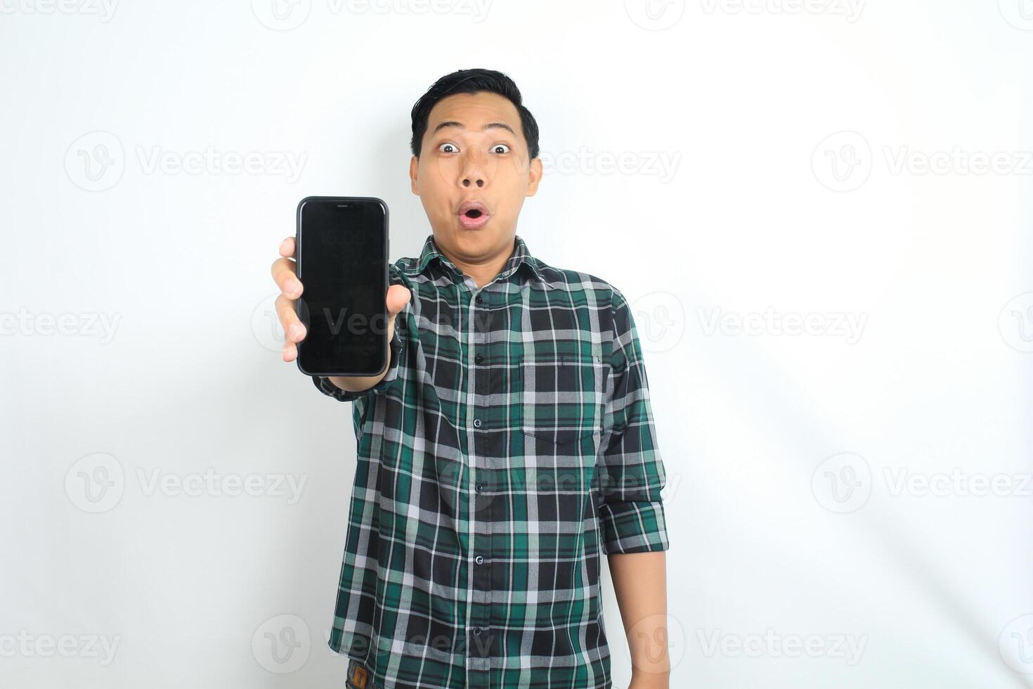 attractive asian man show smartphone screen with surprised face expression isolated on white background photo