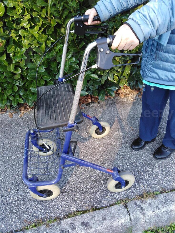 Elderly lady using walker to get around photo