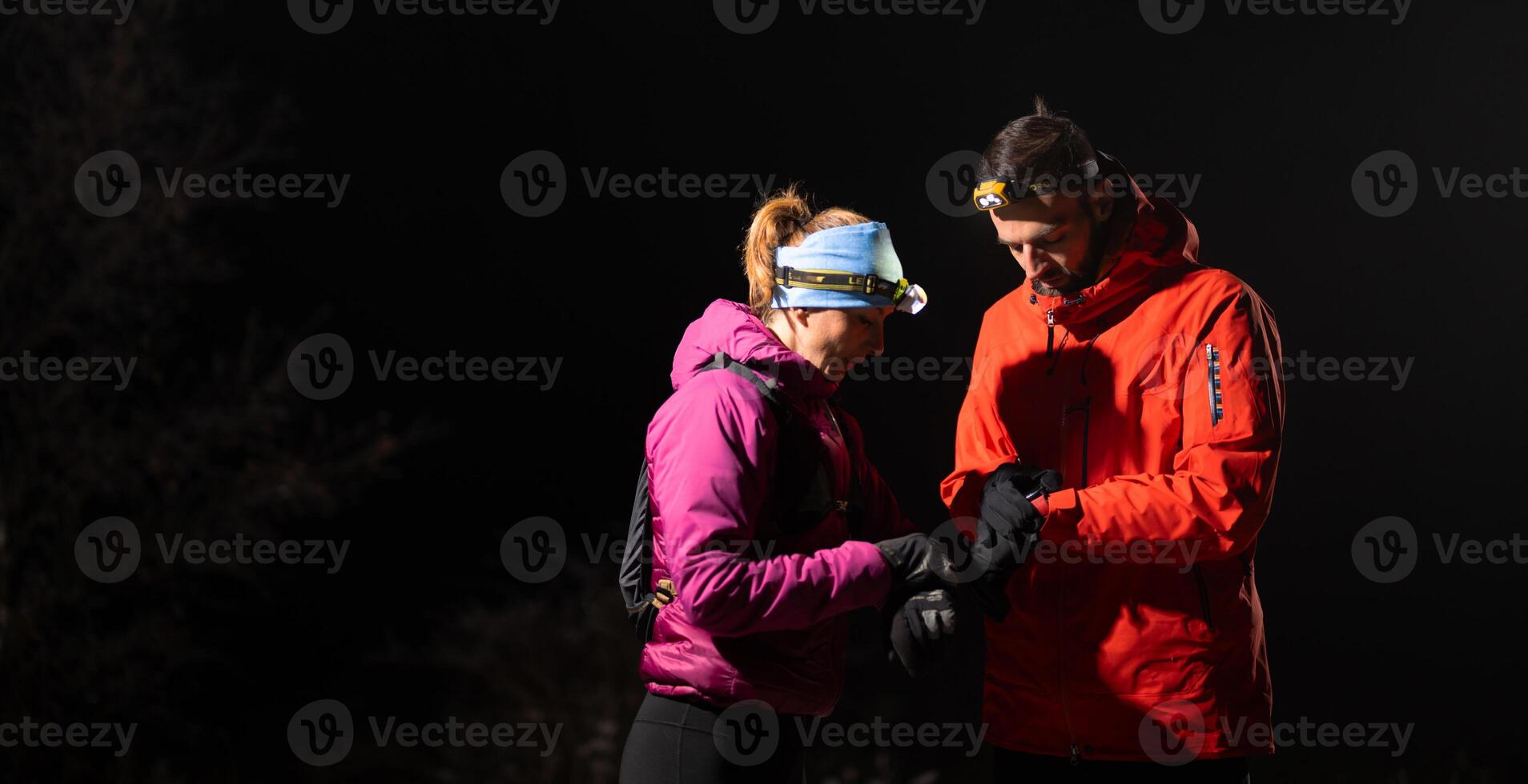 Runners tired of breathing after training look at their tech sports smart watch in night on maintain photo