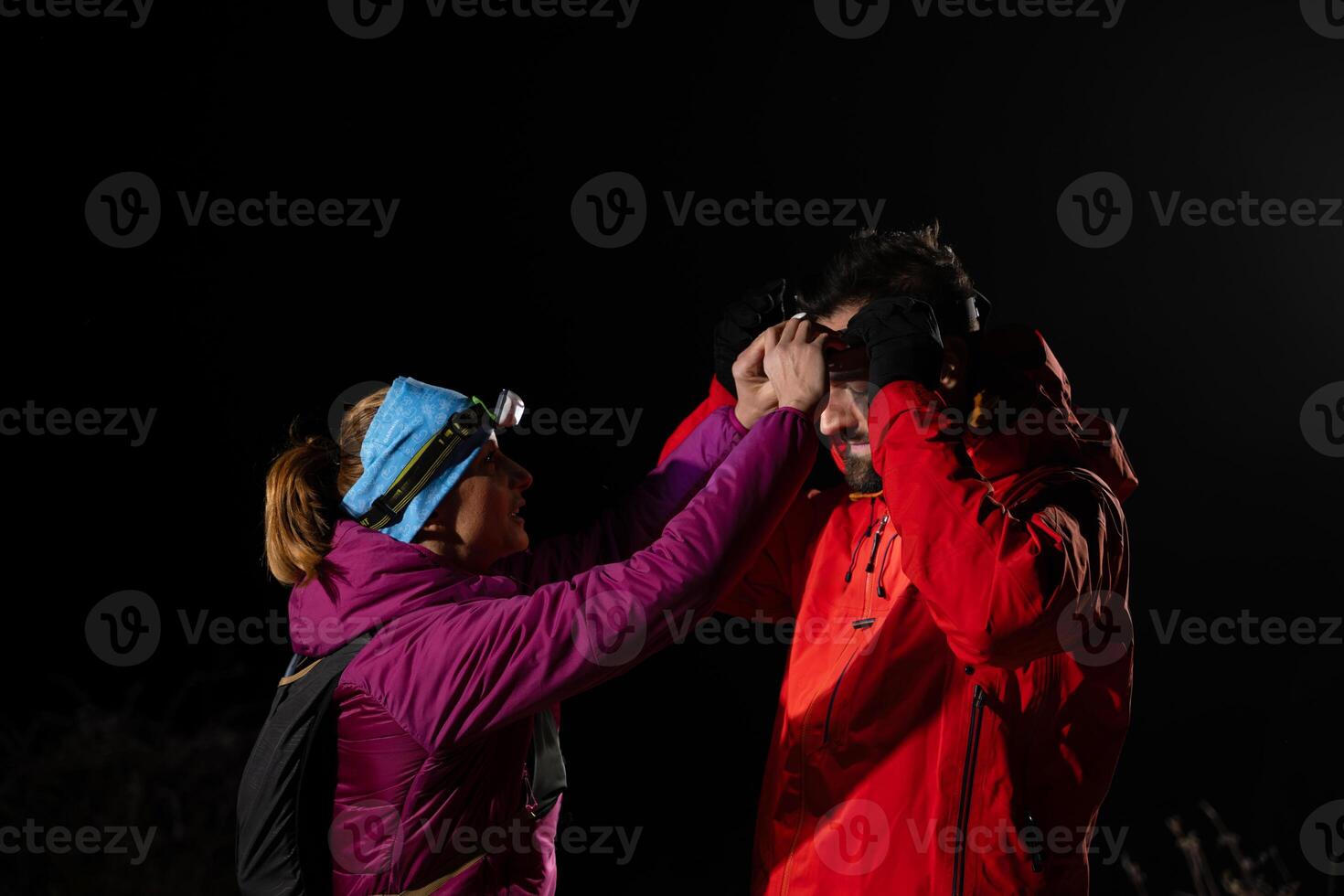 Runners tired of breathing after training look at their tech sports smart watch in night on maintain photo
