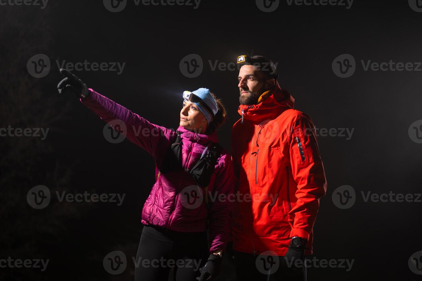 Runners tired of breathing after training look at their tech sports smart watch in night on maintain photo