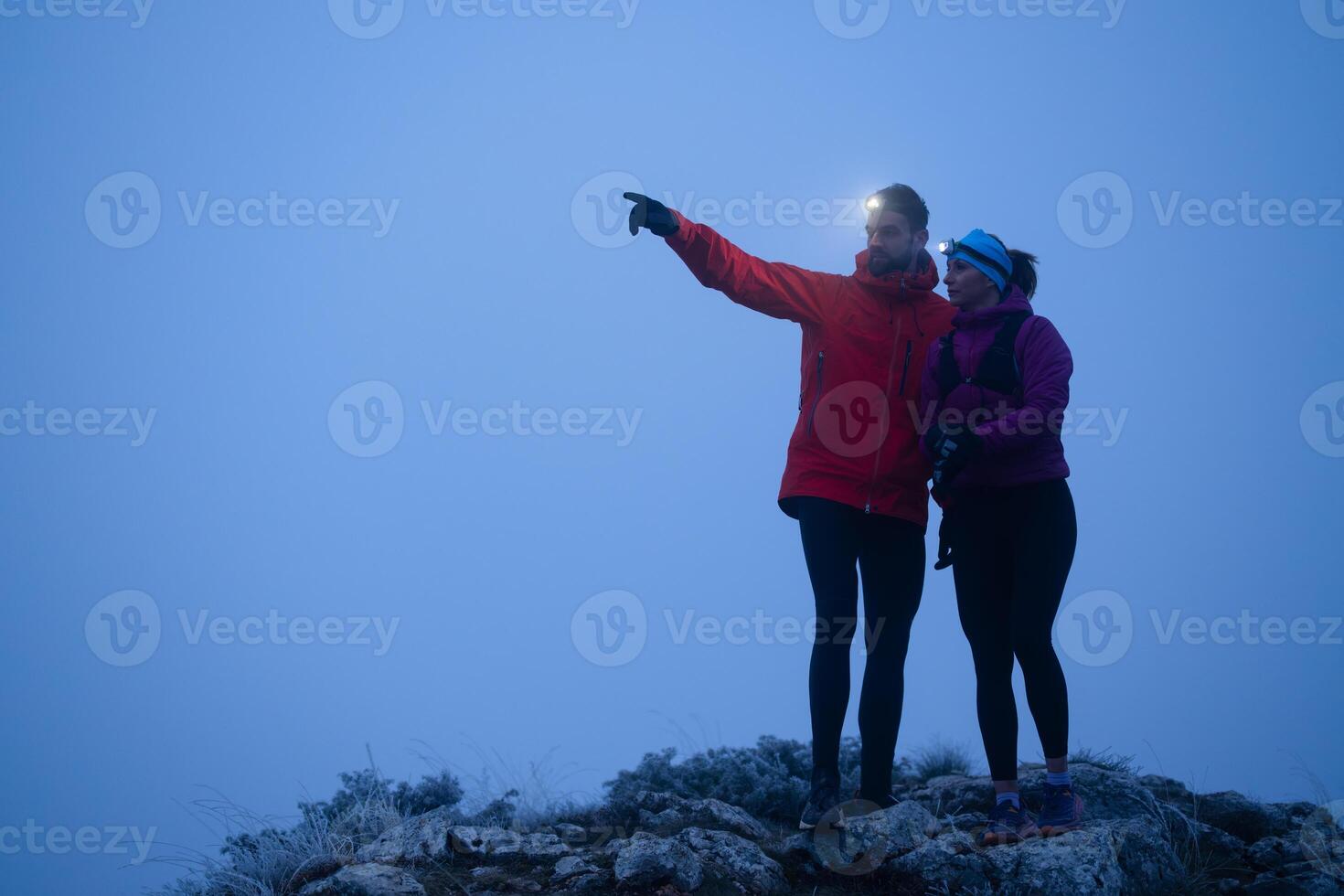 Runners tired of breathing after training look at their tech sports smart watch in night on maintain photo