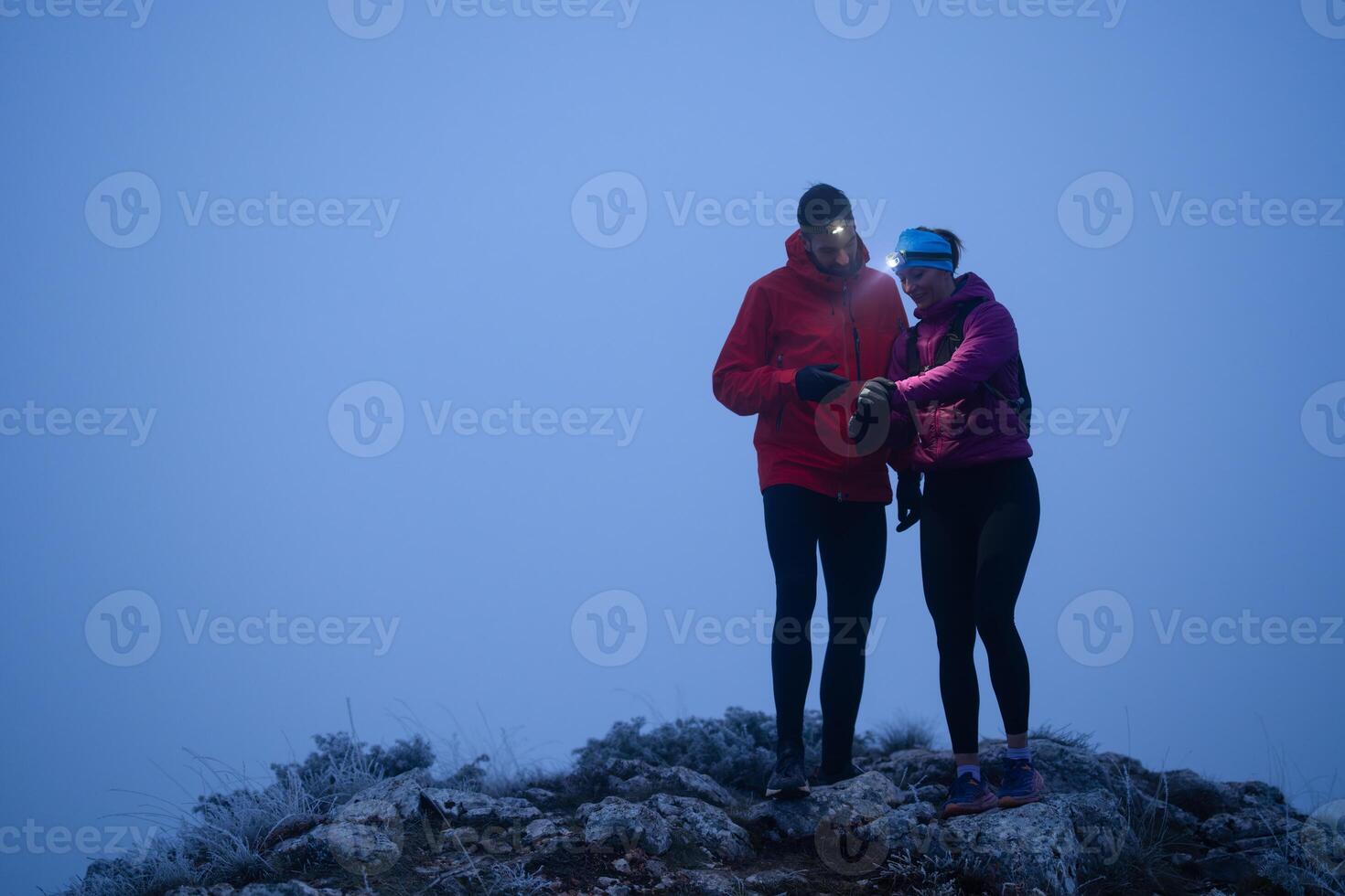 Runners tired of breathing after training look at their tech sports smart watch in night on maintain photo