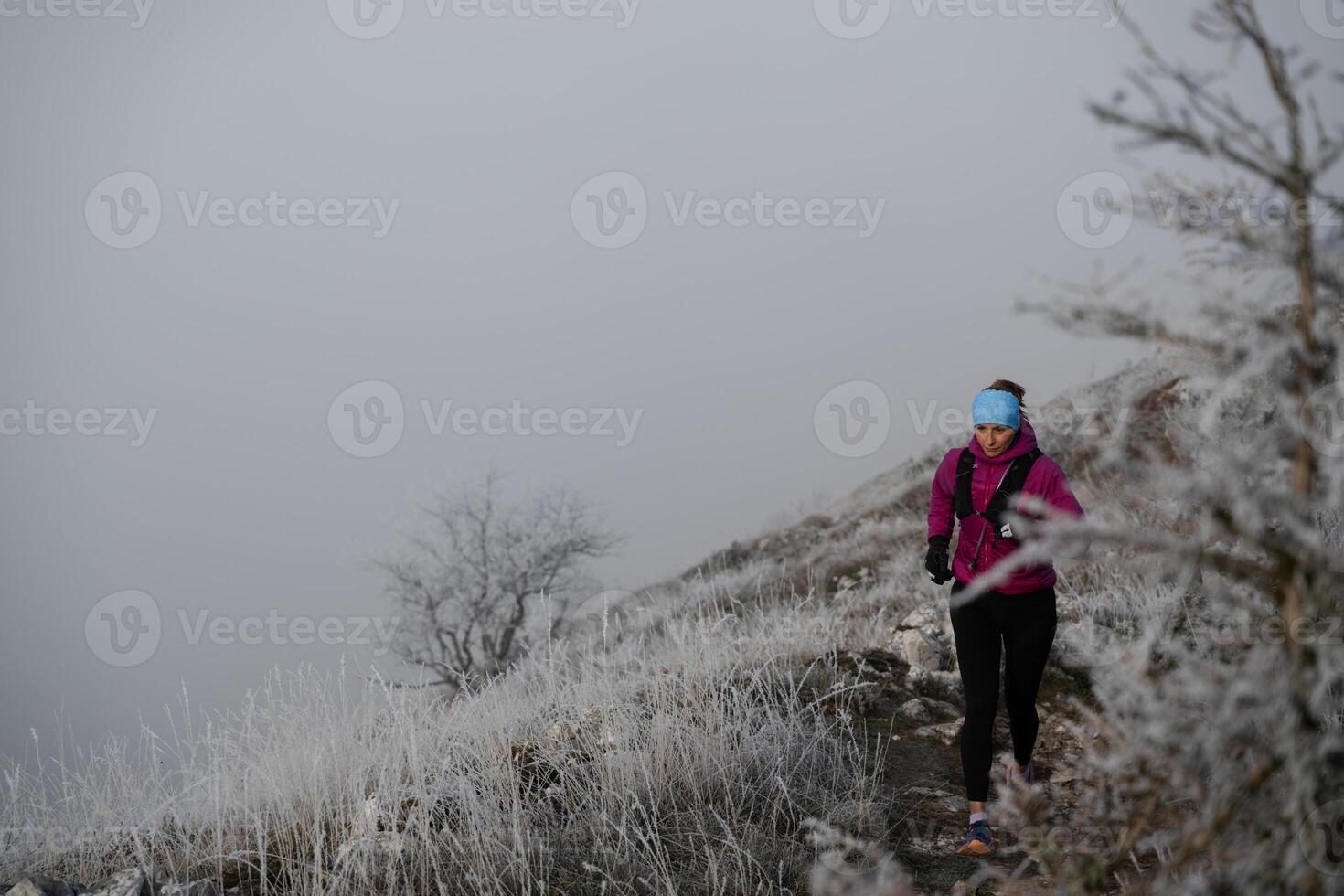 trail running woman athlete prepares for ultra-marathon race in a mountain photo