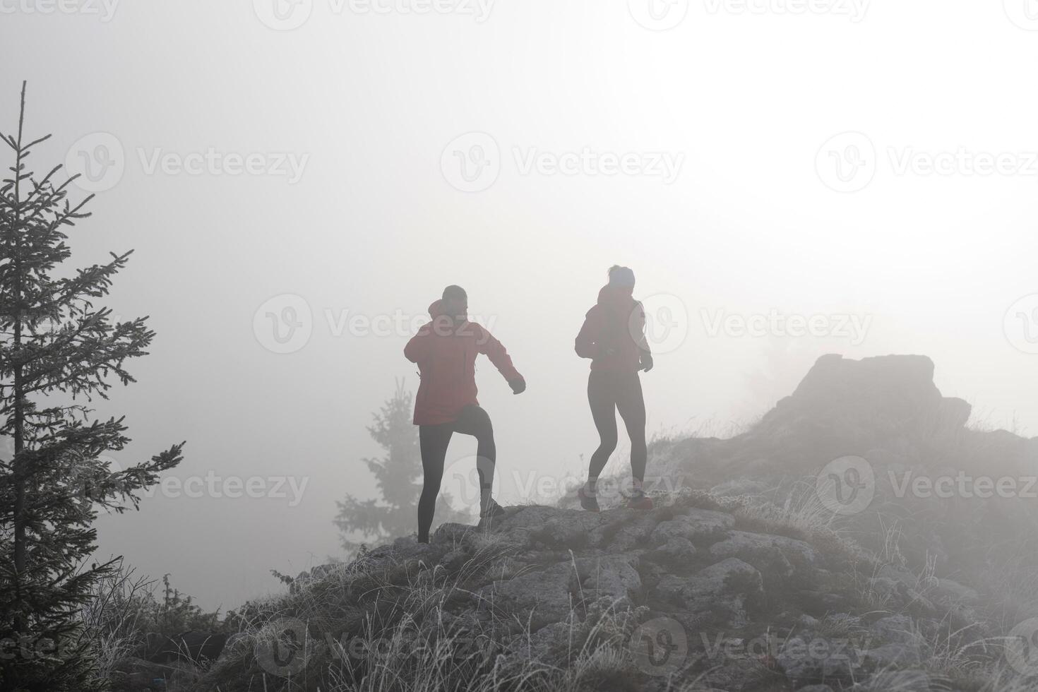 trail running couple man and woman running on a mountain path photo