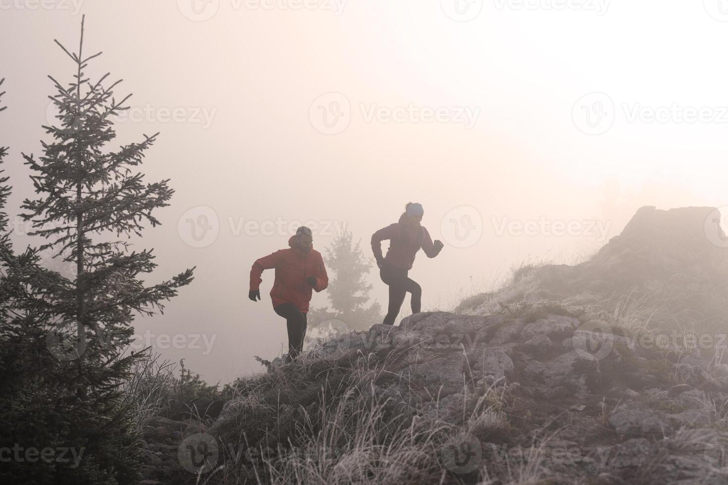 trail running couple man and woman running on a mountain path photo