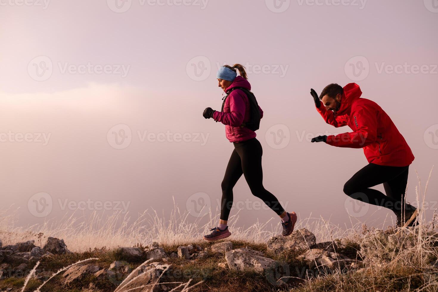 trail running couple man and woman running on a mountain path photo
