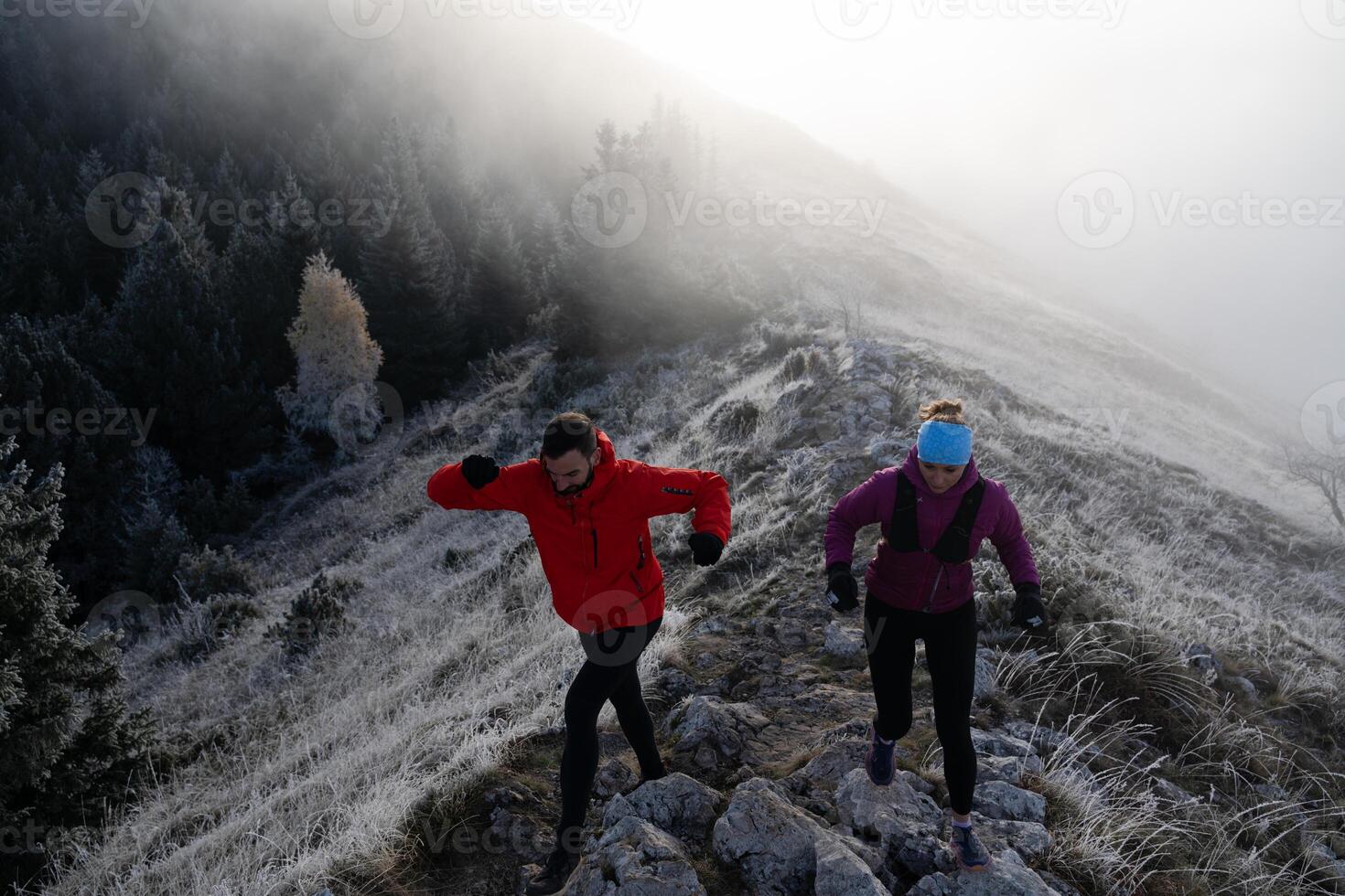 trail running couple man and woman running on a mountain path photo