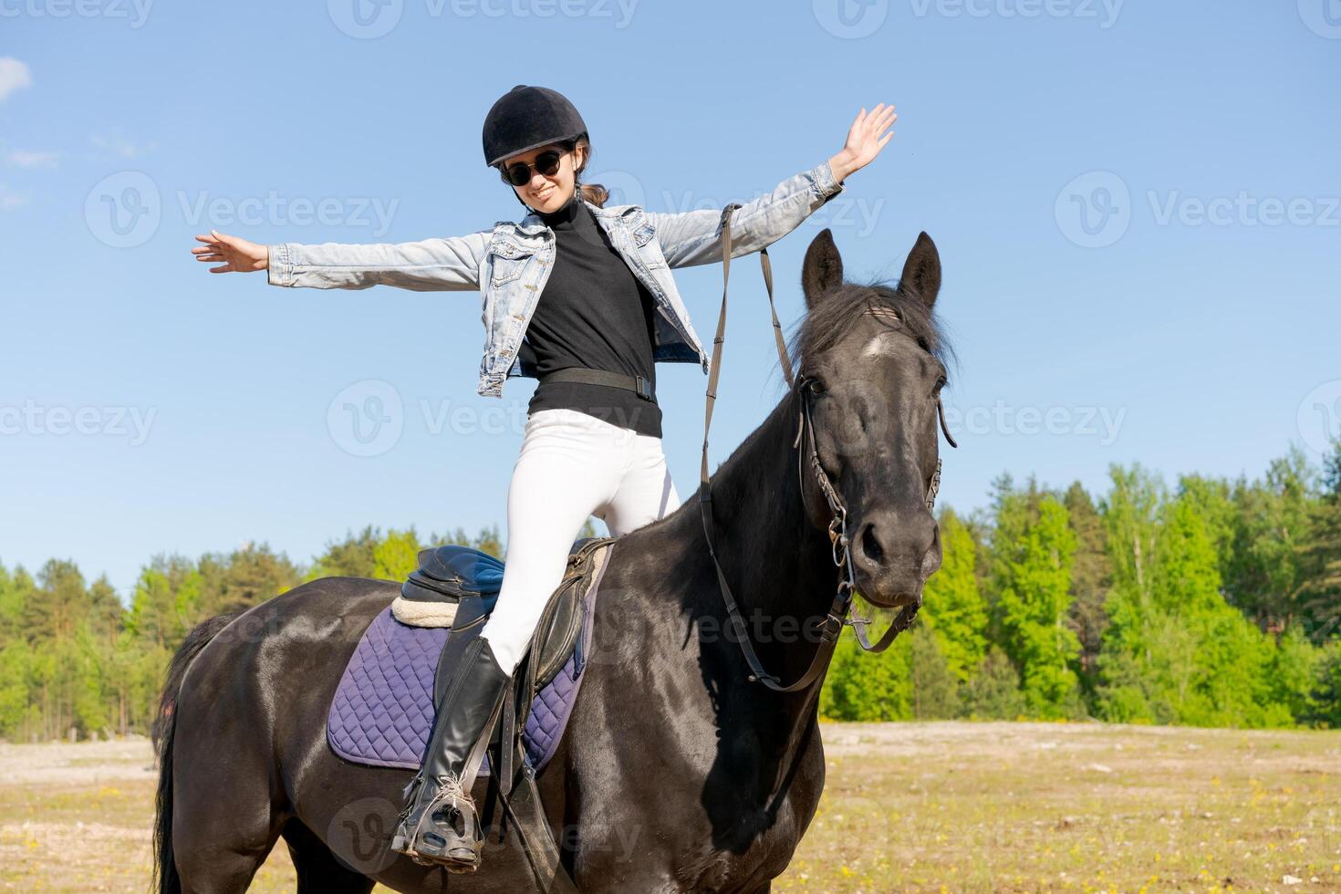 Woman is riding a horse in a field photo