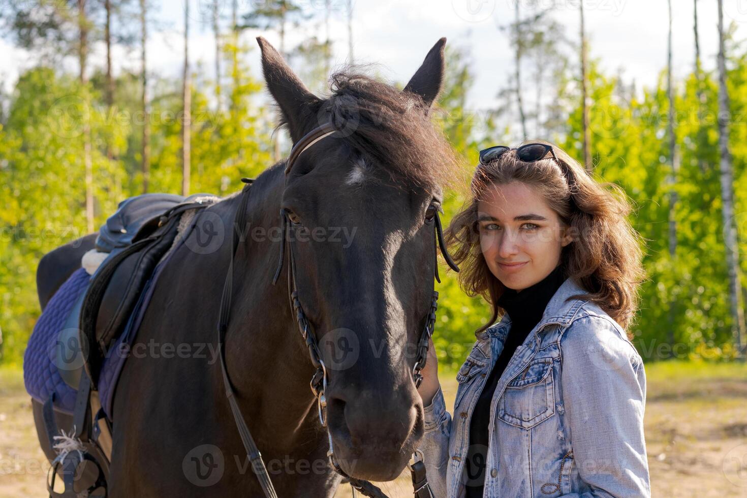 Woman stands next to a black horse photo