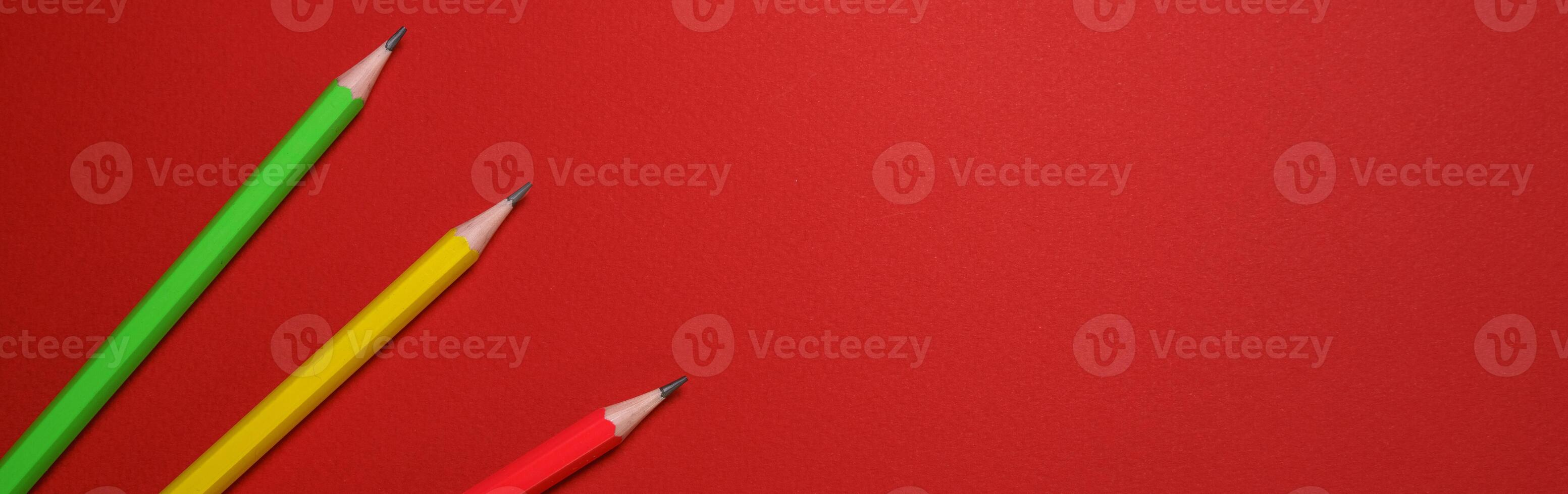 Colored wooden pencils on red background, education concept. photo