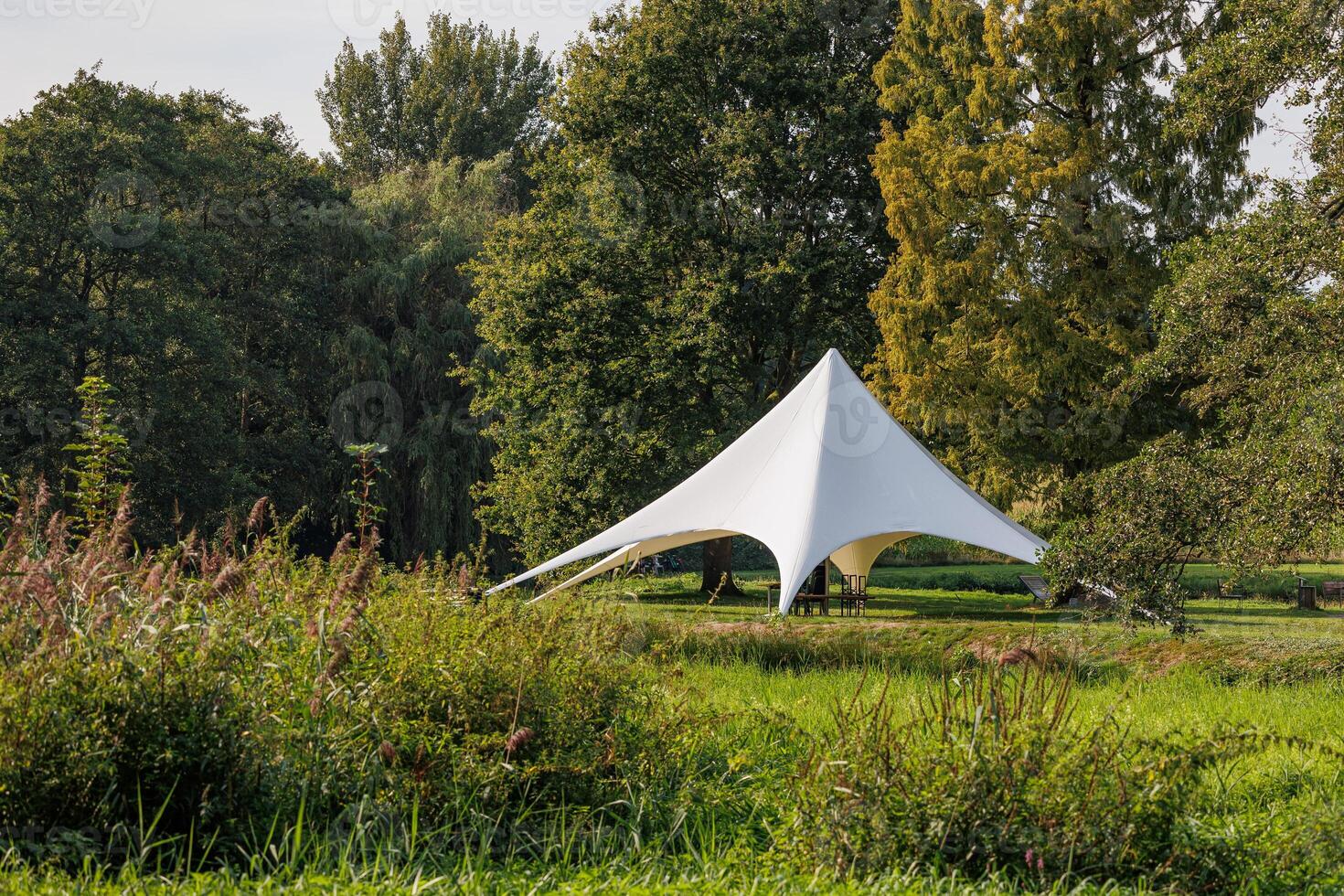 A white tent in a field photo