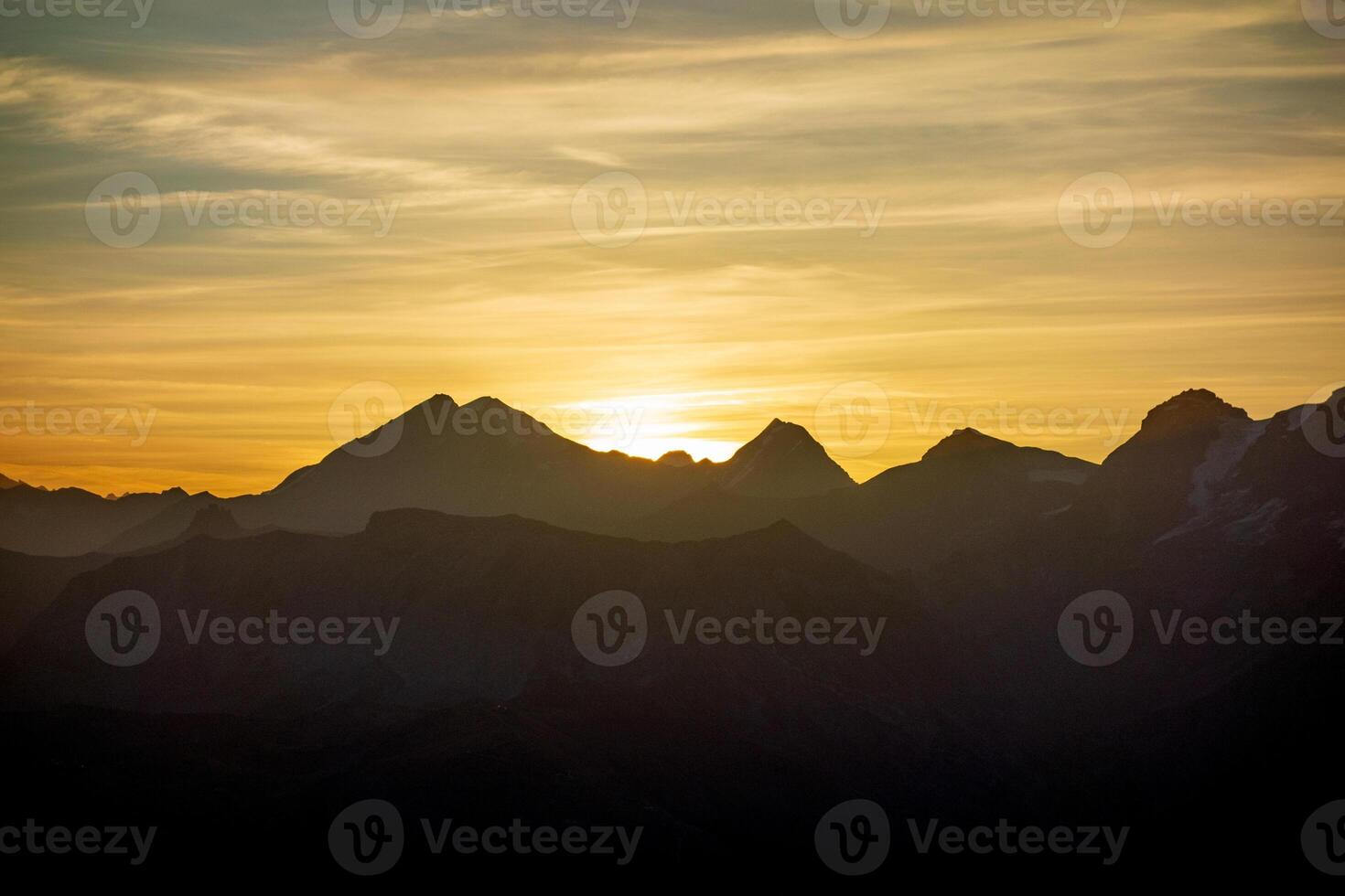 The sun sets over the mountains in this photo
