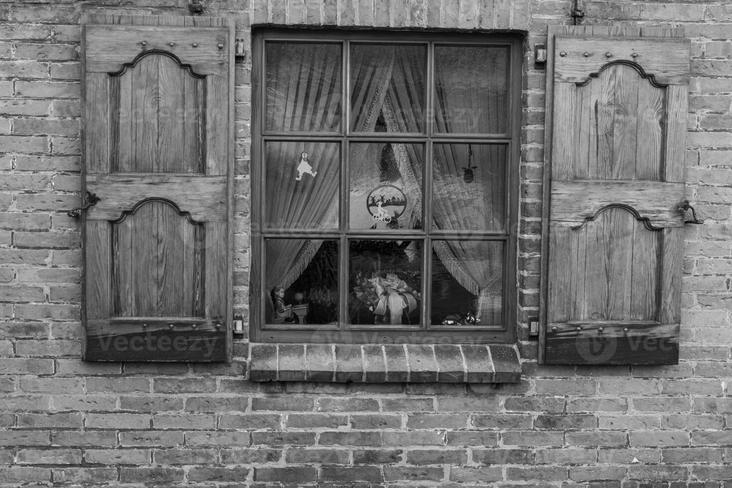 A black and white photo of a window with shutters