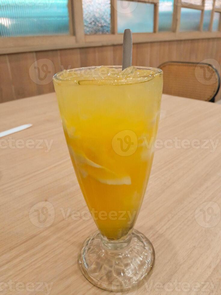 photo of a fresh orange iced drink mixed with shavings of young coconut meat