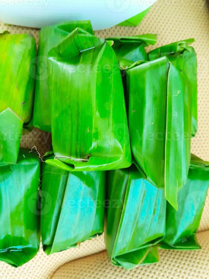 photo of traditional Indonesian snack LEMPER made from sticky rice filled with shredded or stir-fried chicken wrapped in banana leaves