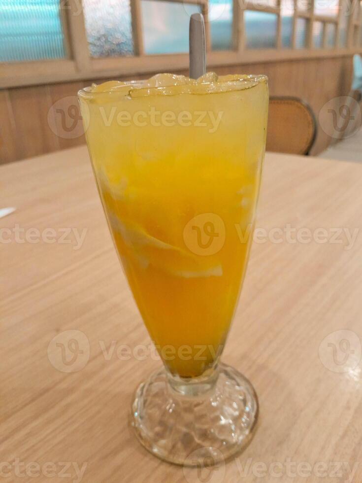 photo of a fresh orange iced drink mixed with shavings of young coconut meat