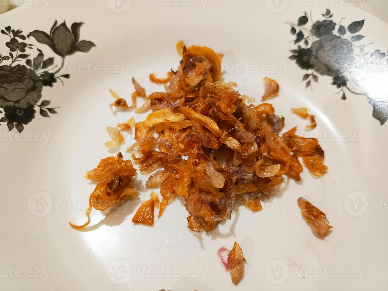 photo of fried shallots on a white and black patterned plate