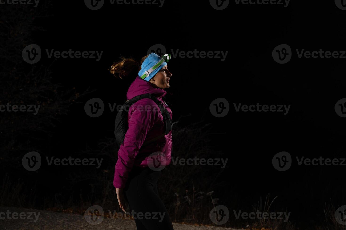 woman in warming sportswear stretching her leg while preparing for trail running in the mountain in early morning photo