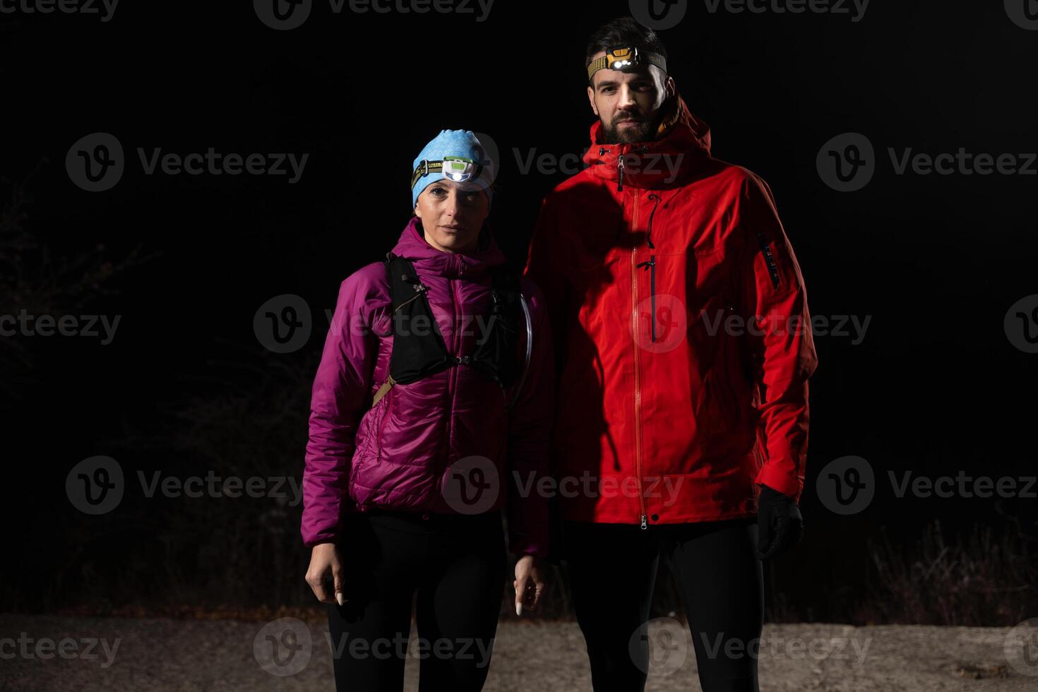 trail runners couple portrait while preparing for an early morning run in the night time with a headlamp photo