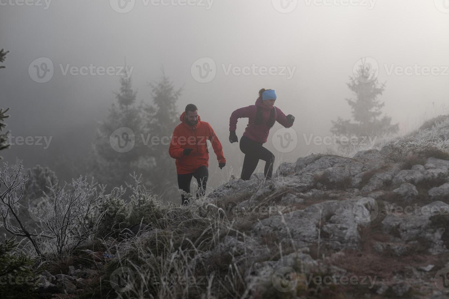 trail running couple man and woman running on a mountain path photo