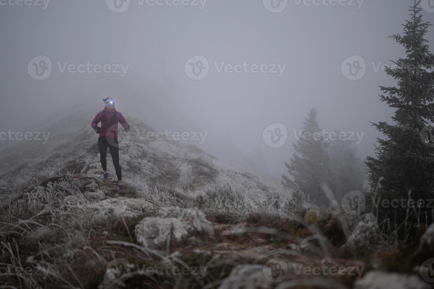 trail running woman athlete training for ultra-marathon race in a mountain photo
