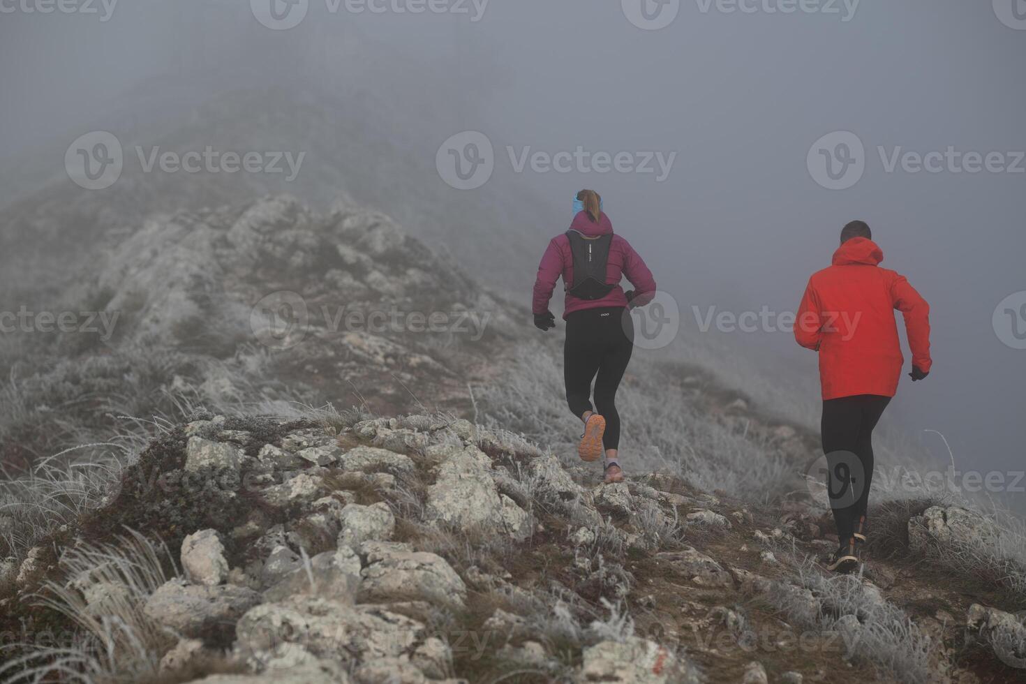 trail running couple man and woman running on a mountain path photo