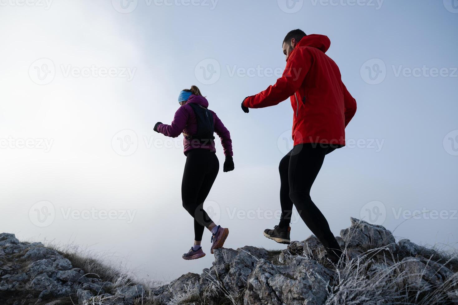 Athlete couple trail running on the mountain top in the early morning. Sky running concept photo