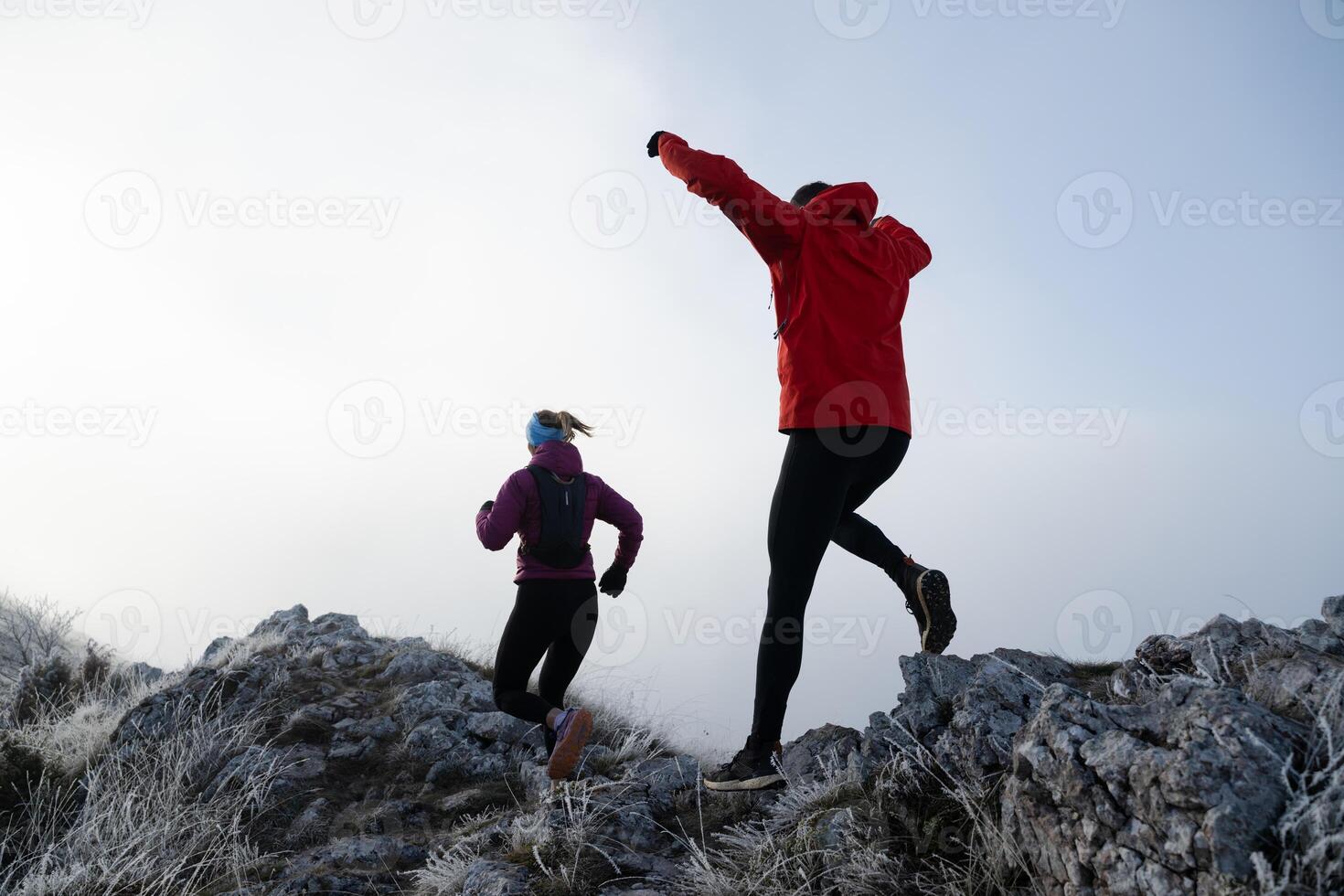 Athlete couple trail running on the mountain top in the early morning. Sky running concept photo