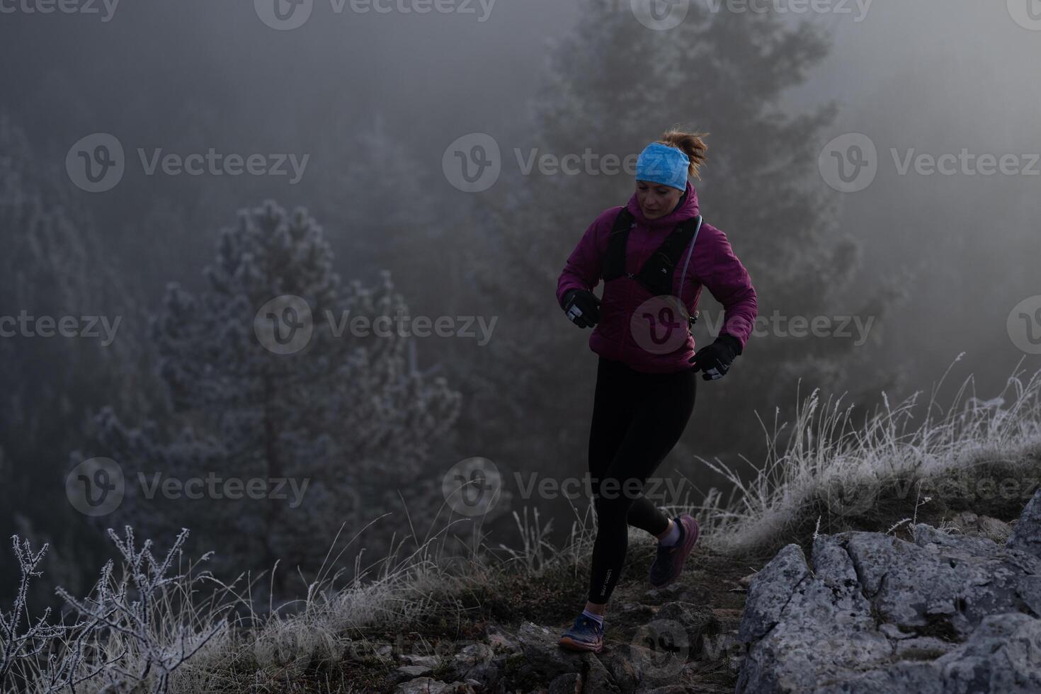 trail running woman athlete training for ultra-marathon race in a mountain photo
