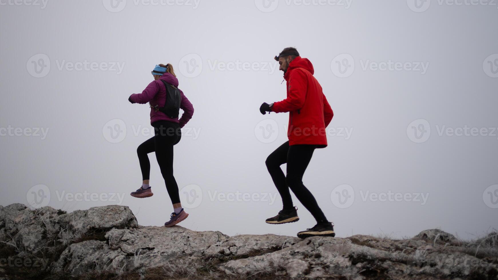 Athlete couple trail running on the mountain top in the early morning. Sky running concept photo