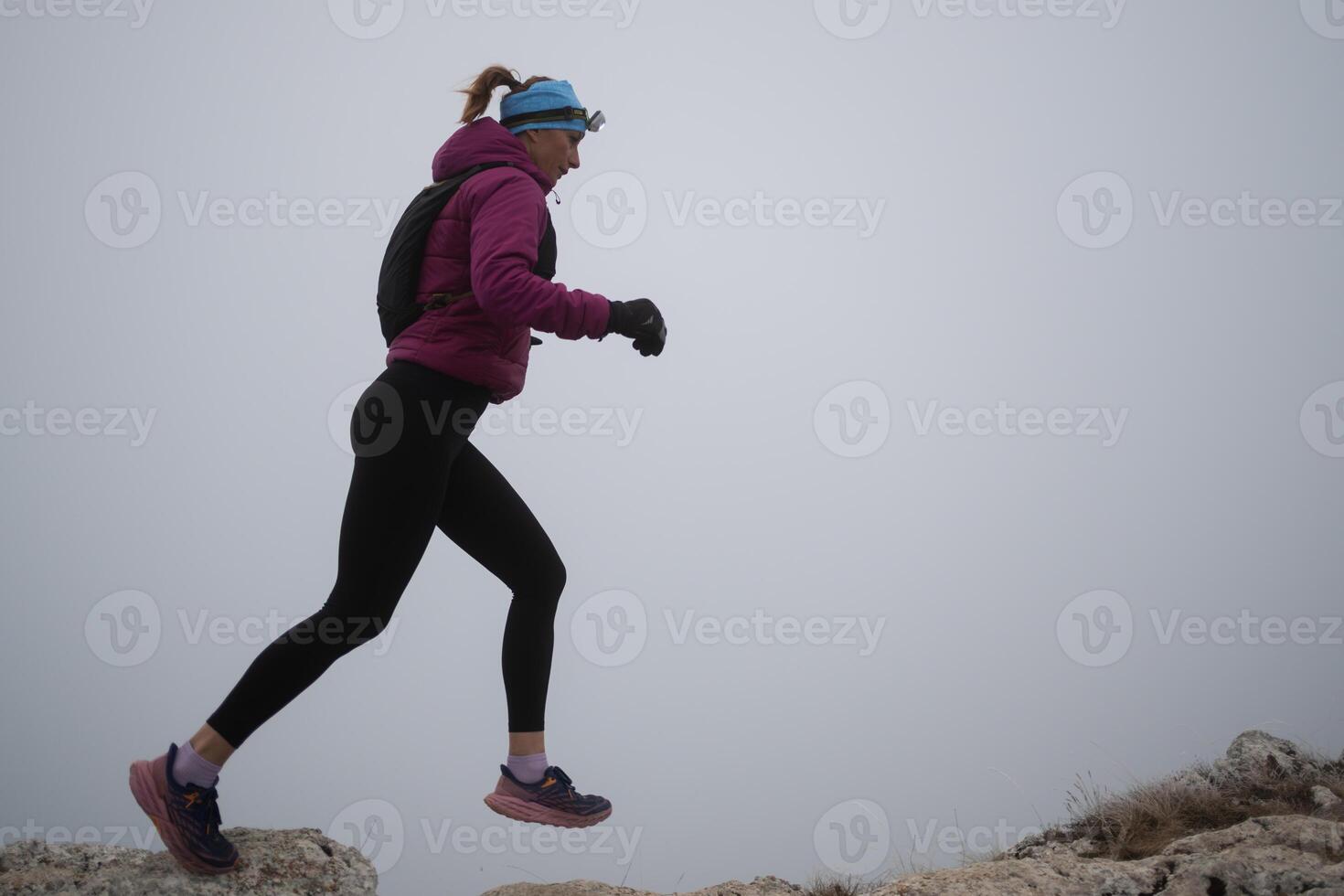 sky running or trail running woman exercising on a mountain top photo