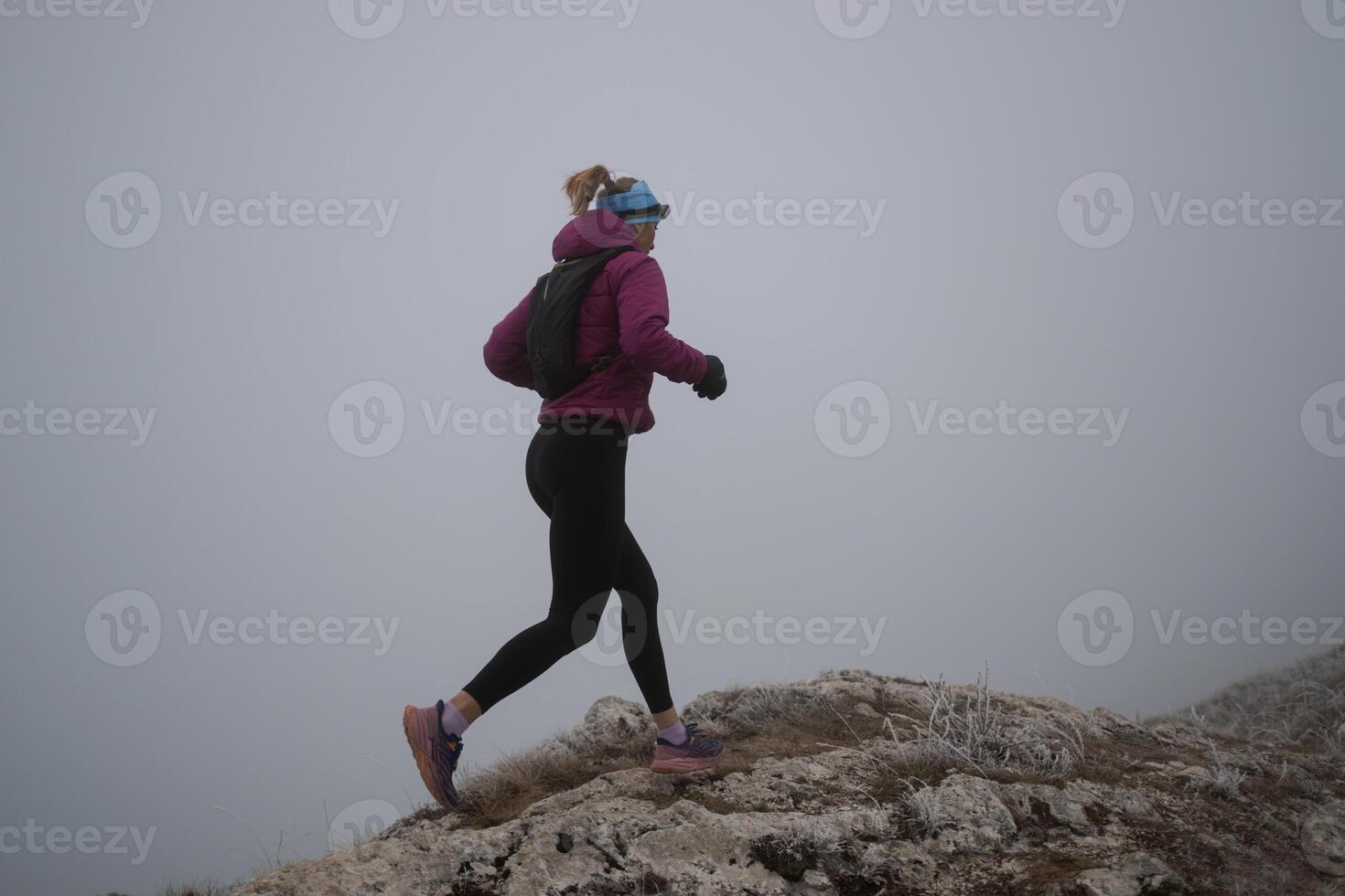 sky running or trail running woman exercising on a mountain top photo