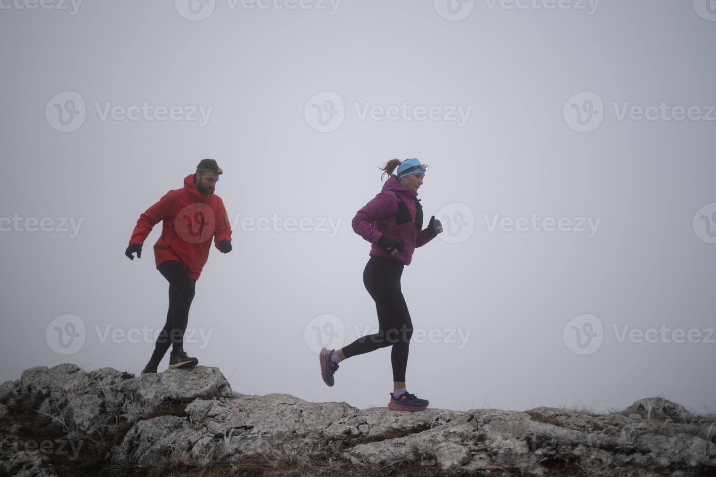 Athlete couple trail running on the mountain top in the early morning. Sky running concept photo