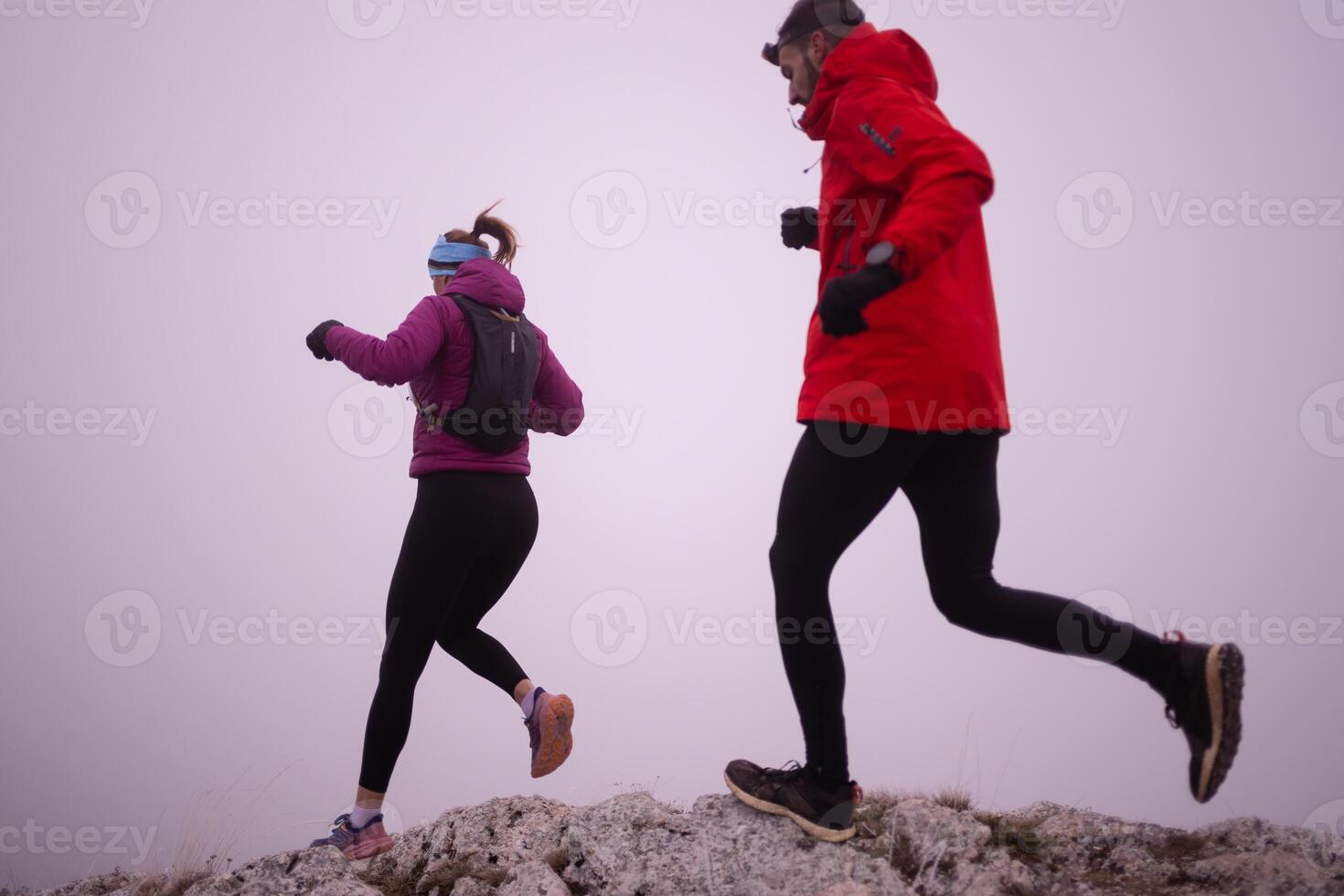 Athlete couple trail running on the mountain top in the early morning. Sky running concept photo