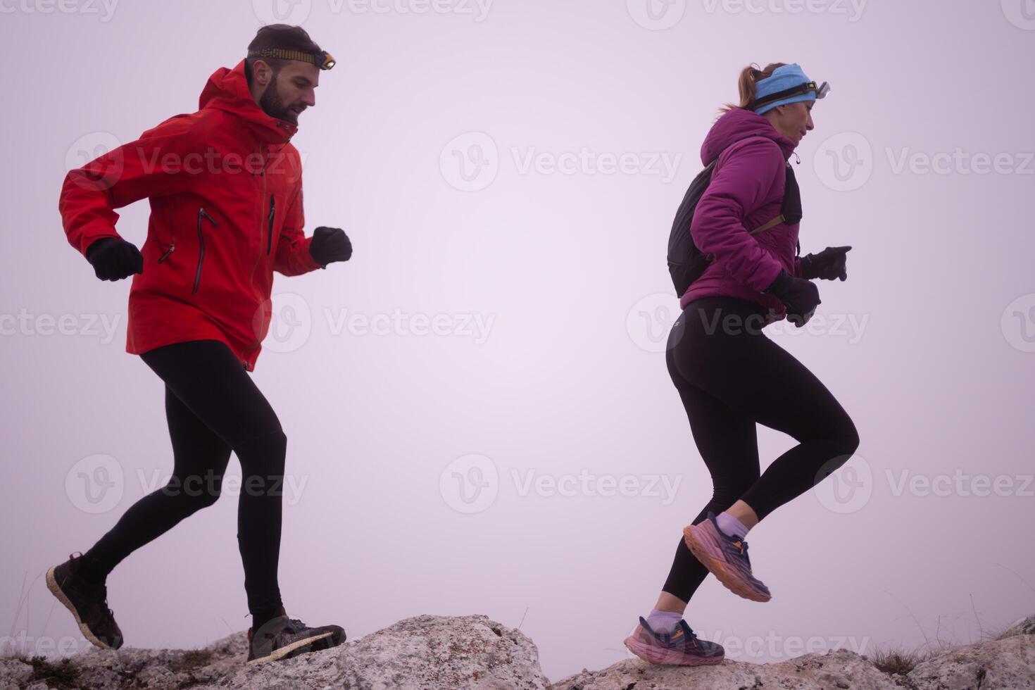Athlete couple trail running on the mountain top in the early morning. Sky running concept photo