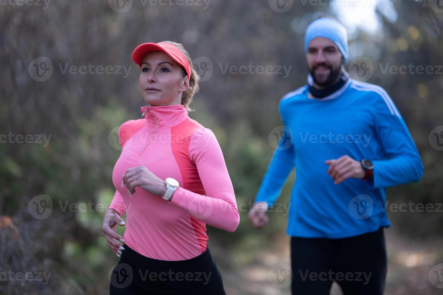trail running with a sporty couple in the magic forest in early morning photo